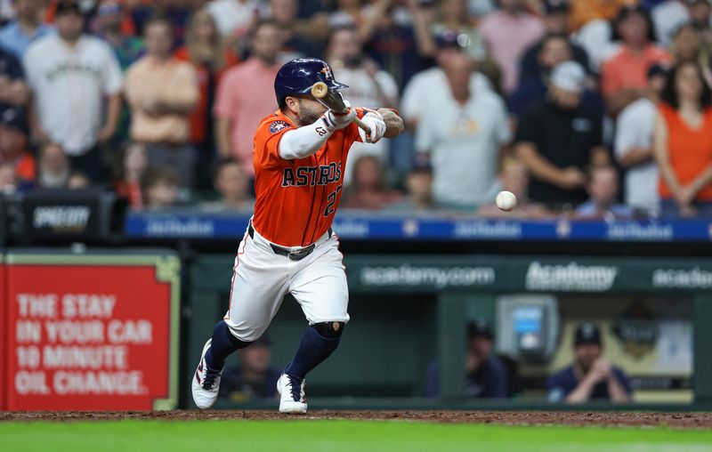 May 3, 2024; Houston, Texas, USA; Houston Astros second baseman Jose Altuve (27) drives in a run with a bunt single during the seventh inning against the Seattle Mariners at Minute Maid Park. Mandatory Credit: Troy Taormina-USA TODAY Sports