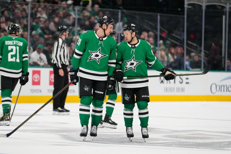 Oct 13, 2024; Dallas, Texas, USA; Dallas Stars center Roope Hintz (24) and right wing Evgenii Dadonov (63) talk during a break in play against the Seattle Kraken during the first period at American Airlines Center. Mandatory Credit: Chris Jones-Imagn Images