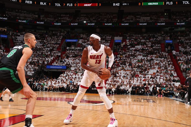 MIAMI, FL - APRIL 27: Bam Adebayo #13 of the Miami Heat handles the ball against Kristaps Porzingis #8 of the Boston Celtics during the game during Round 1 Game 3 of the 2024 NBA Playoffs on April 27, 2024 at Kaseya Center in Miami, Florida. NOTE TO USER: User expressly acknowledges and agrees that, by downloading and or using this Photograph, user is consenting to the terms and conditions of the Getty Images License Agreement. Mandatory Copyright Notice: Copyright 2024 NBAE (Photo by Issac Baldizon/NBAE via Getty Images)