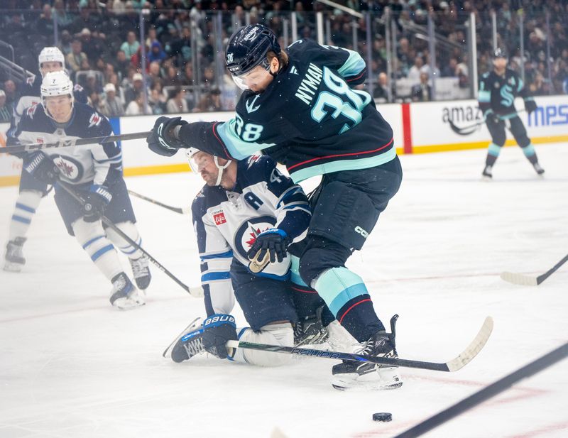 Mar 16, 2025; Seattle, Washington, USA;  Seattle Kraken foward Jani Nyman (38) and Winnipeg Jets defenseman Josh Morrissey (44) battle for the puck during the third period at Climate Pledge Arena. Mandatory Credit: Stephen Brashear-Imagn Images