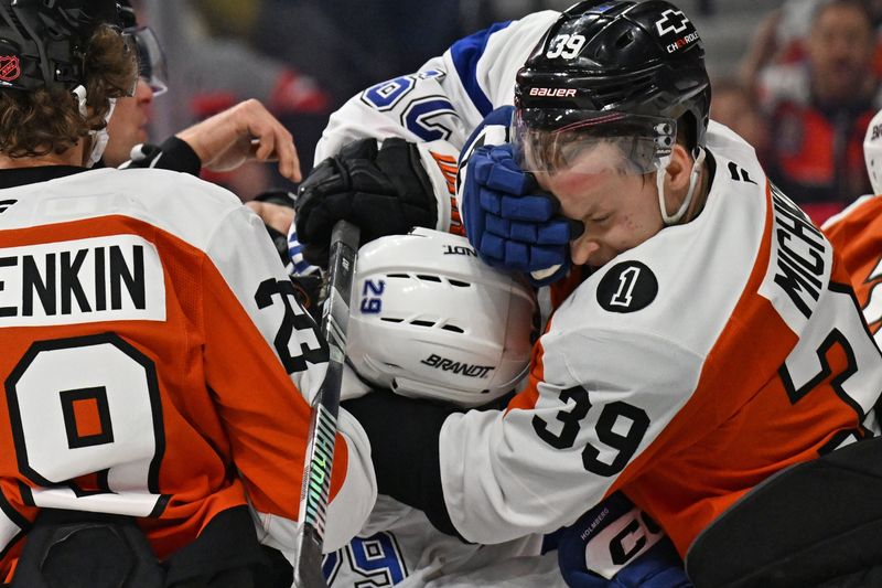 Jan 10, 2026; Philadelphia, Pennsylvania, USA; Tampa Bay Lightning center Zemgus Girgensons (28) and Philadelphia Flyers right wing Matvei Michkov (39) during a scrum in the second period at Xfinity Mobile Arena. Mandatory Credit: Eric Hartline-Imagn Images