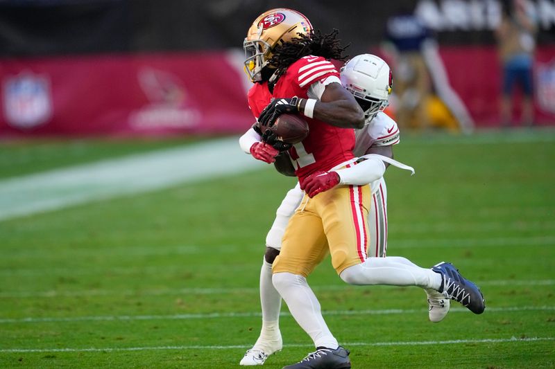 San Francisco 49ers wide receiver Brandon Aiyuk, left, is tackled by Arizona Cardinals cornerback Starling Thomas V during the first half of an NFL football game, Sunday, Dec. 17, 2023, in Glendale, Ariz. (AP Photo/Matt York)