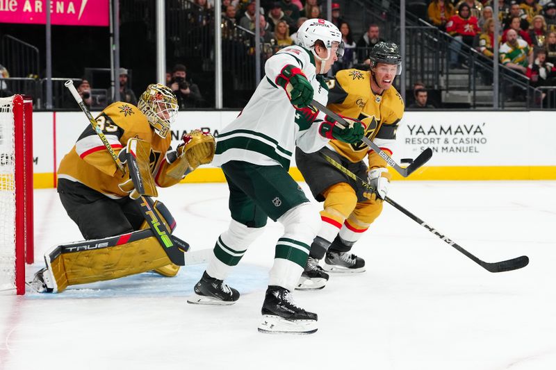 Feb 12, 2024; Las Vegas, Nevada, USA; Vegas Golden Knights defenseman Brayden McNabb (3) attempts a block as Minnesota Wild left wing Matt Boldy (12) deflects a shot towards Vegas Golden Knights goaltender Adin Hill (33) during the second period at T-Mobile Arena. Mandatory Credit: Stephen R. Sylvanie-USA TODAY Sports