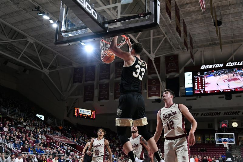 Jan 14, 2023; Chestnut Hill, Massachusetts, USA; Wake Forest Demon Deacons forward Matthew Marsh (33) hang from the basket after dunking the ball during the first half against the Boston College Eagles at Conte Forum. Mandatory Credit: Eric Canha-USA TODAY Sports