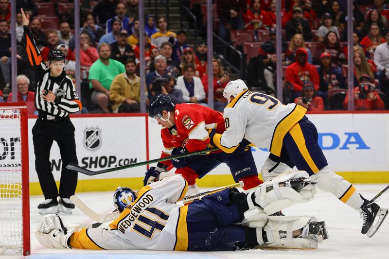 Nov 7, 2024; Sunrise, Florida, USA; Florida Panthers center Evan Rodrigues (17) moves the puck as Nashville Predators center Ryan O'Reilly (90) and goaltender Scott Wedgewood (41) defend during the second period at Amerant Bank Arena. Mandatory Credit: Sam Navarro-Imagn Images