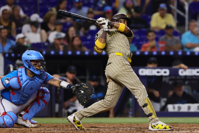 Aug 11, 2024; Miami, Florida, USA; San Diego Padres first baseman Luis Arraez (4) hits a double against the Miami Marlins during the sixth inning at loanDepot Park. Mandatory Credit: Sam Navarro-USA TODAY Sports