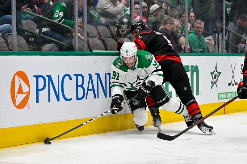 Jan 25, 2023; Dallas, Texas, USA; Dallas Stars center Tyler Seguin (91) dives for the puck as Carolina Hurricanes defenseman Jalen Chatfield (5) attempts to check him during the second period at the American Airlines Center. Mandatory Credit: Jerome Miron-USA TODAY Sports