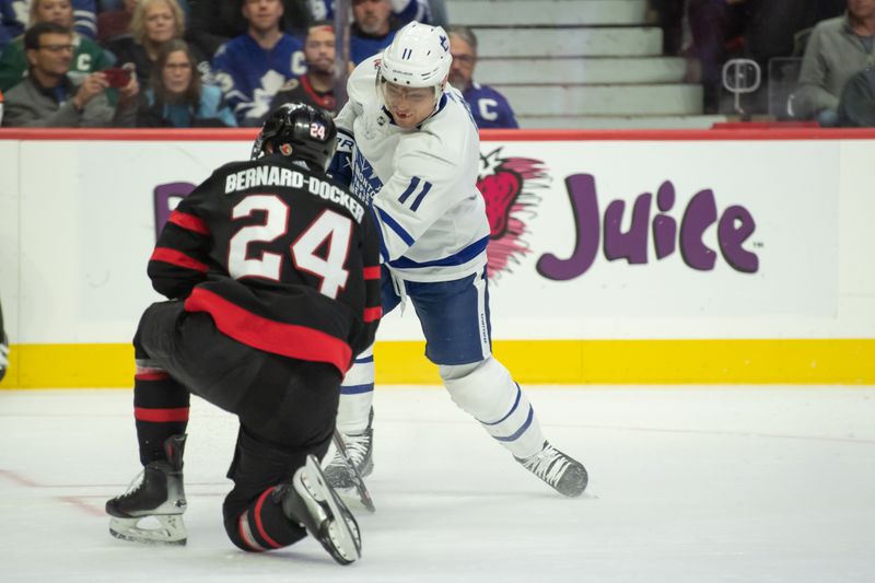 Dec 7, 2023; Ottawa, Ontario, CAN; Ottawa Senators defenseman Jacob Bernard-Docker (24) blocks a shot from Toronto Maple Leafs center Max Domi (11) in the second period at the Canadian Tire Centre. Mandatory Credit: Marc DesRosiers-USA TODAY Sports