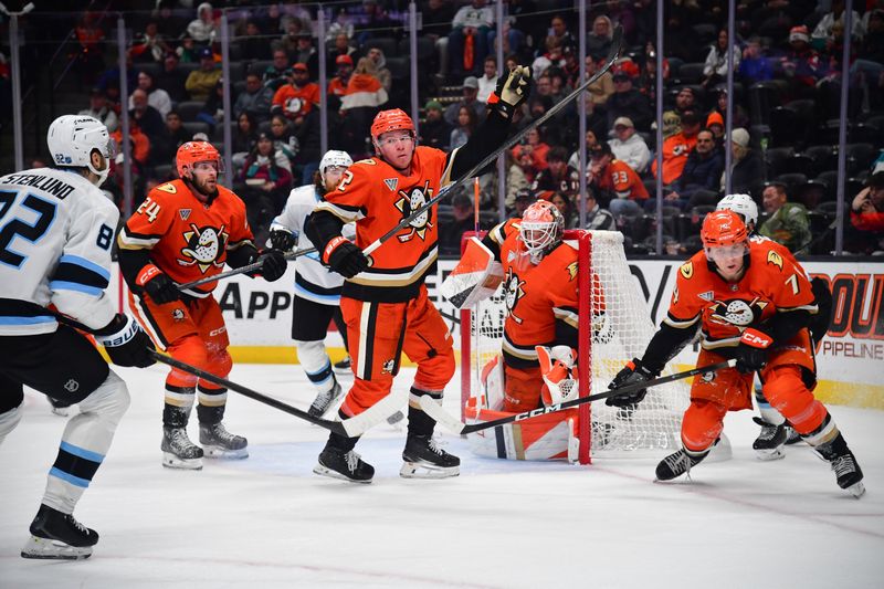 Nov 17, 2025; Anaheim, California, USA; Anaheim Ducks defenseman Jackson Lacombe (2) gets control of the puck as Utah Mammoth center Kevin Stenlund (82) moves in during the third period at Honda Center. Mandatory Credit: Gary A. Vasquez-Imagn Images