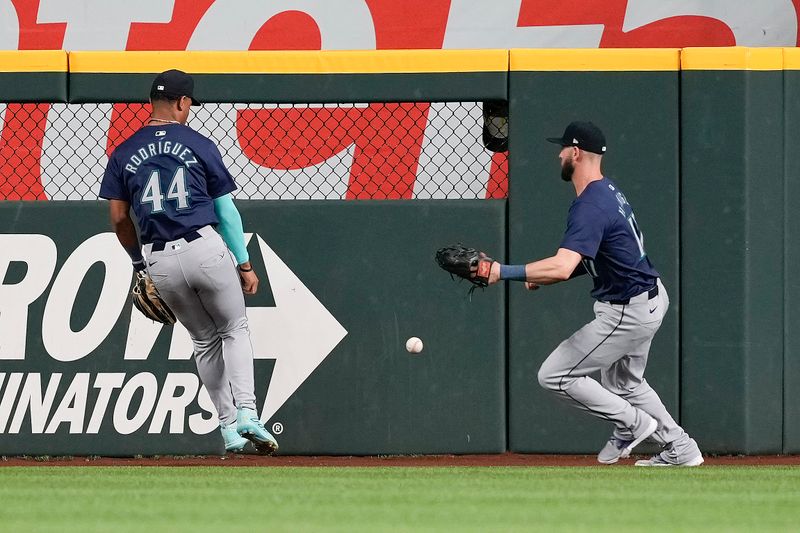 Apr 24, 2024; Arlington, Texas, USA; Seattle Mariners center fielder Julio Rodríguez (44) and right fielder Mitch Haniger (17) chase a double hit by Texas Rangers designated hitter Wyatt Langford (not pictured) during the second inning at Globe Life Field. Mandatory Credit: Jim Cowsert-USA TODAY Sports