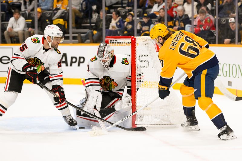 Jan 16, 2025; Nashville, Tennessee, USA;  Chicago Blackhawks goaltender Arvid Soderblom (40) blocks the shot of Nashville Predators left wing Zachary L'Heureux (68) during the first period at Bridgestone Arena. Mandatory Credit: Steve Roberts-Imagn Images