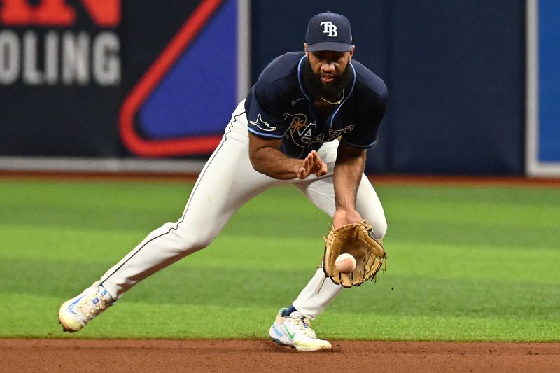 Jun 26, 2024; St. Petersburg, Florida, USA; Tampa Bay Rays second base Amed Rosario (10) fields a ground ball against the Seattle Mariners in the sixth inning at Tropicana Field. Mandatory Credit: Jonathan Dyer-USA TODAY Sports