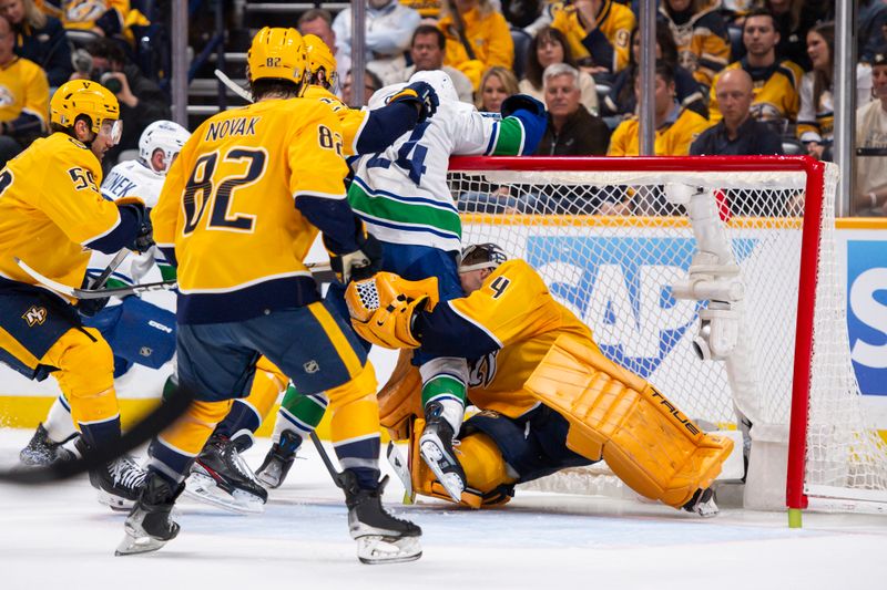 Apr 26, 2024; Nashville, Tennessee, USA; Vancouver Canucks center Pius Suter (24) collides with Nashville Predators goaltender Juuse Saros (74) during the second period in game three of the first round of the 2024 Stanley Cup Playoffs at Bridgestone Arena. Mandatory Credit: Steve Roberts-USA TODAY Sports