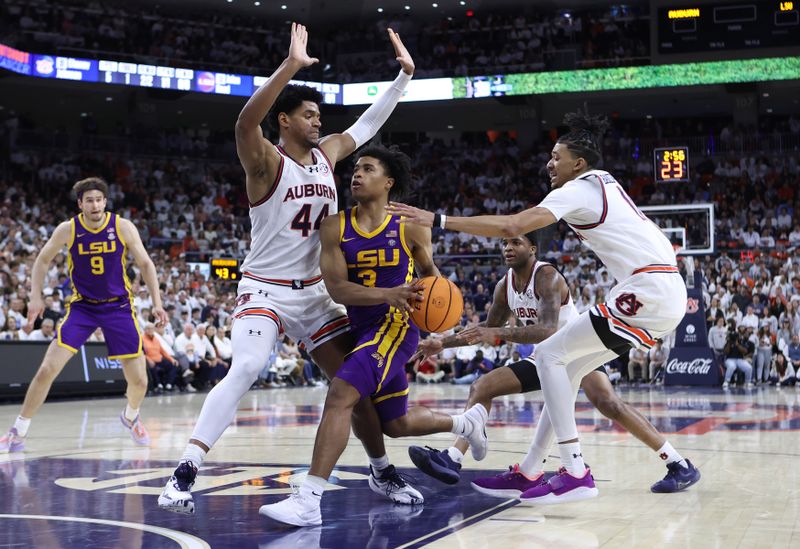 Jan 13, 2024; Auburn, Alabama, USA; LSU Tigers guard Jalen Cook (3) goes for a shot as Auburn Tigers center Dylan Cardwell (44) and  guard Chad Baker-Mazara (10) defend during the first half at Neville Arena. Mandatory Credit: John Reed-USA TODAY Sports