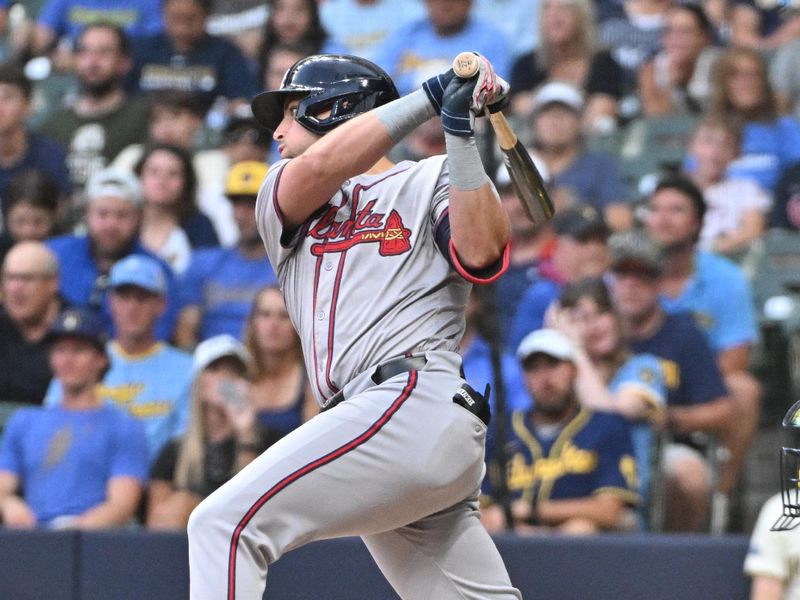 Jul 30, 2024; Milwaukee, Wisconsin, USA; Atlanta Braves third base Austin Riley (27) drives in a run against the Milwaukee Brewers in the third inning at American Family Field. Mandatory Credit: Michael McLoone-USA TODAY Sports