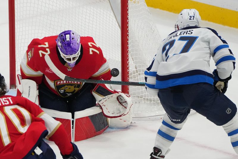 Nov 16, 2024; Sunrise, Florida, USA;  Florida Panthers goaltender Sergei Bobrovsky (72) makes a save against Winnipeg Jets left wing Nikolaj Ehlers (27) during the third period at Amerant Bank Arena. Mandatory Credit: Jim Rassol-Imagn Images