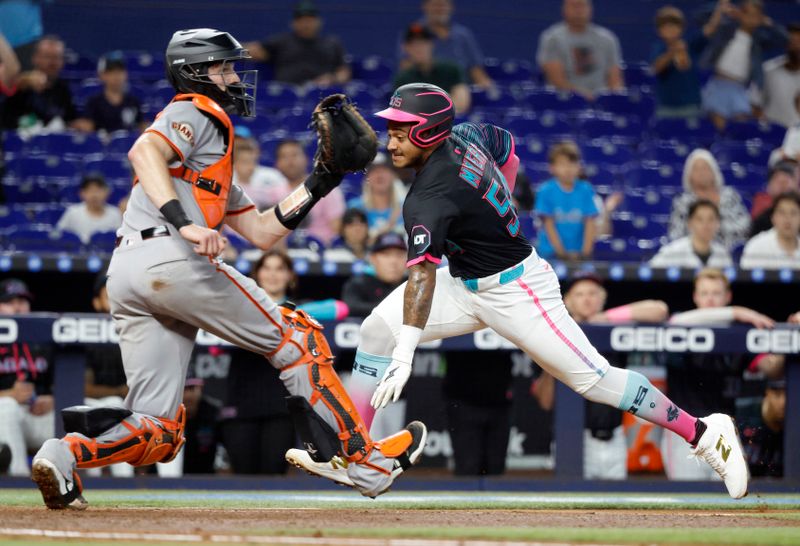 May 31, 2025; Miami, Florida, USA;  Miami Marlins center fielder Dane Myers (54) scores behind San Francisco Giants catcher Patrick Bailey (14) during the second inning at loanDepot Park. Mandatory Credit: Rhona Wise-Imagn Images