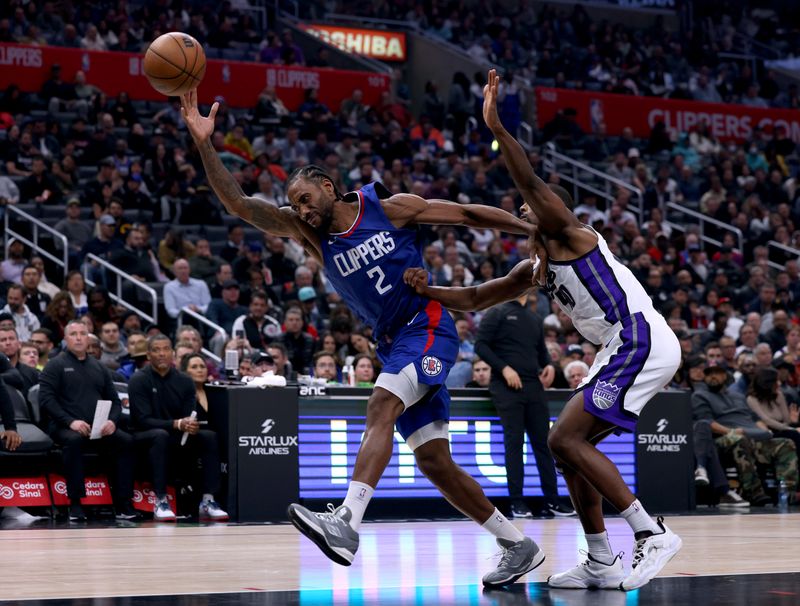 LOS ANGELES, CALIFORNIA - DECEMBER 12: Kawhi Leonard #2 of the LA Clippers reacts as he is pushed by Harrison Barnes #40 of the Sacramento Kings reaching for a pass during the first half at Crypto.com Arena on December 12, 2023 in Los Angeles, California.  NOTE TO USER: User expressly acknowledges and agrees that, by downloading and or using this photograph, User is consenting to the terms and conditions of the Getty Images License Agreement. (Photo by Harry How/Getty Images)