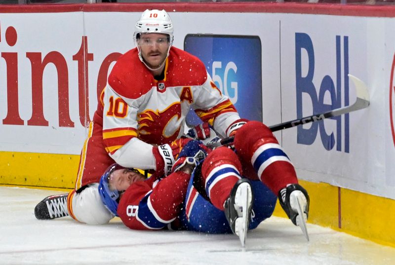 Nov 14, 2023; Montreal, Quebec, CAN; Calgary Flames forward Jonathan Huberdeau (10) falls on Montreal Canadiens defenseman Mike Matheson (8) during the second period at the Bell Centre. Mandatory Credit: Eric Bolte-USA TODAY Sports