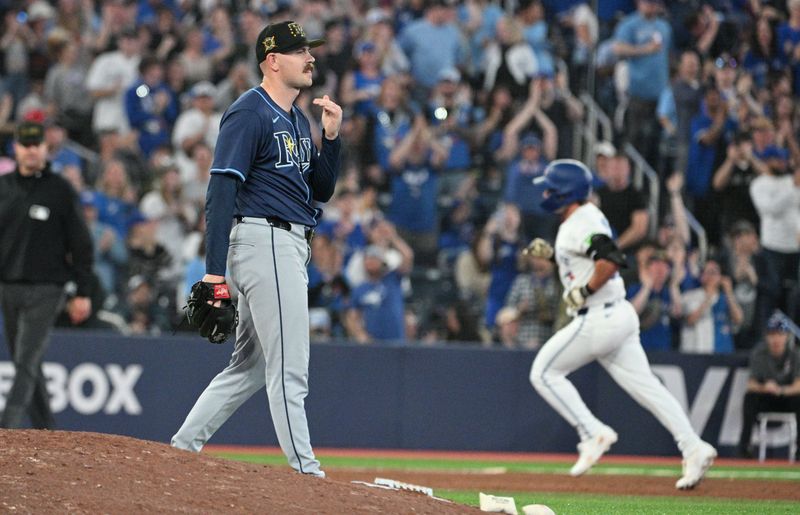 May 17, 2024; Toronto, Ontario, CAN;   Tampa Bay Rays pitcher Tyler Alexander (14) prepares for his next pitch as Toronto Blue Jays left fielder Davis Schneider (36) rounds the bases after hitting a two run home run in the eighth inning at Rogers Centre. Mandatory Credit: Dan Hamilton-USA TODAY Sports