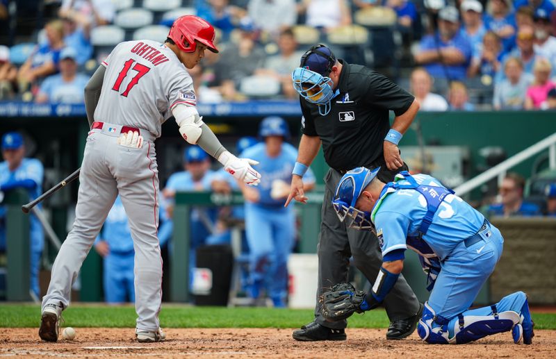 Jun 18, 2023; Kansas City, Missouri, USA; Los Angeles Angels designated hitter Shohei Ohtani (17) checks on Kansas City Royals catcher Freddy Fermin (34) after hitting him during his swing in the fifth inning at Kauffman Stadium. Mandatory Credit: Jay Biggerstaff-USA TODAY Sports