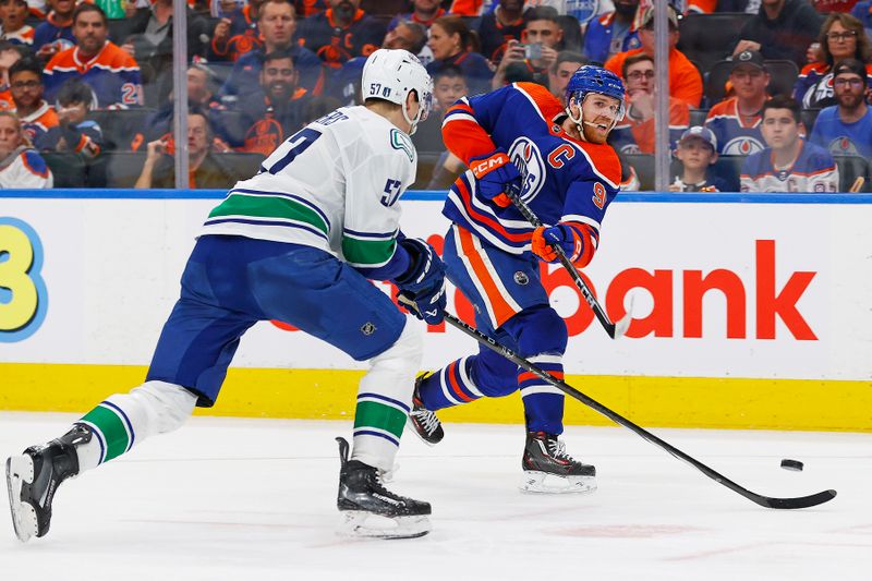 May 14, 2024; Edmonton, Alberta, CAN; Edmonton Oilers forward Connor McDavid (97) gets a shot away in front of Vancouver Canucks defensemen Tyler Myers (57) during the third period in game four of the second round of the 2024 Stanley Cup Playoffs at Rogers Place. Mandatory Credit: Perry Nelson-USA TODAY Sports