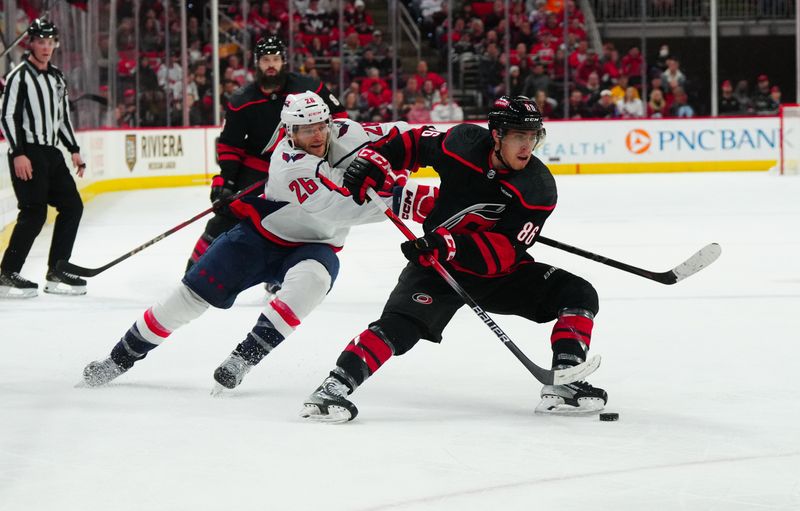 Apr 5, 2024; Raleigh, North Carolina, USA; Carolina Hurricanes left wing Teuvo Teravainen (86) skates with the puck inside Washington Capitals center Nic Dowd (26) during the third period at PNC Arena. Mandatory Credit: James Guillory-USA TODAY Sports