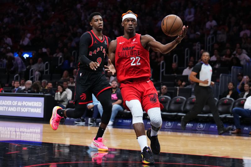 MIAMI, FLORIDA - DECEMBER 12: Jimmy Butler #22 of the Miami Heat dribbles the ball against RJ Barrett #9 of the Toronto Raptors during the second quarter at Kaseya Center on December 12, 2024 in Miami, Florida. NOTE TO USER: User expressly acknowledges and agrees that, by downloading and or using this Photograph, user is consenting to the terms and conditions of the Getty Images License Agreement. (Photo by Rich Storry/Getty Images)