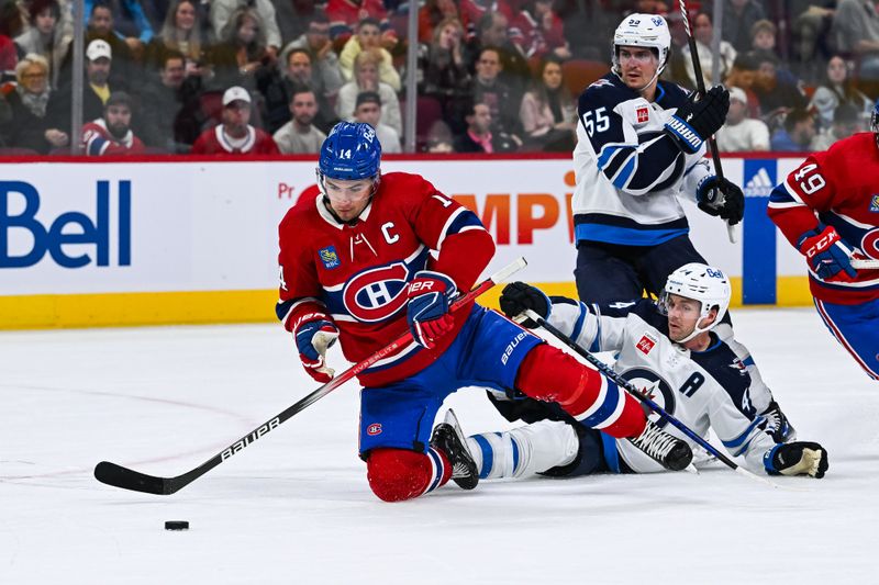 Oct 28, 2023; Montreal, Quebec, CAN; Montreal Canadiens center Nick Suzuki (14) attempts to maintain control of the puck as he falls on the ice  near Winnipeg Jets defenseman Josh Morrissey (44)) during the second period at Bell Centre. Mandatory Credit: David Kirouac-USA TODAY Sports