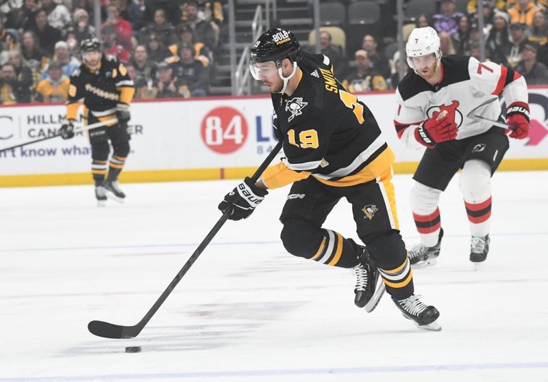 Nov 16, 2023; Pittsburgh, Pennsylvania, USA; Pittsburgh Penguins right wing Reilly Smith (19) skates with the puck against the New Jersey Devils defenseman Dougie Hamilton (7) during the first period at PPG Paints Arena. Mandatory Credit: Philip G. Pavely-USA TODAY Sports