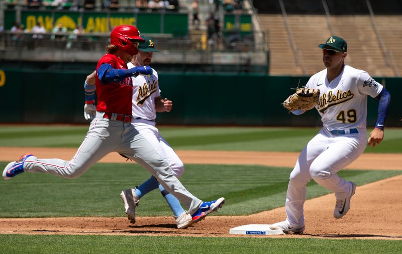 Jun 18, 2023; Oakland, California, USA; Oakland Athletics first baseman Ryan Noda (49) beats Philadelphia Phillies second basema nBryson Stott (5) to first on a ground ball during the fourth inning at Oakland-Alameda County Coliseum. Mandatory Credit: D. Ross Cameron-USA TODAY Sports