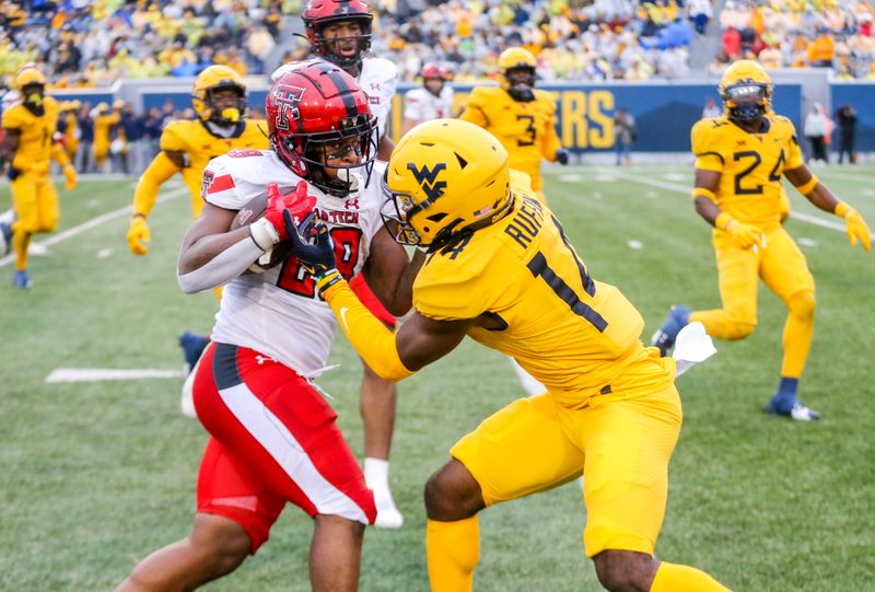 Sep 23, 2023; Morgantown, West Virginia, USA; Texas Tech Red Raiders running back Tahj Brooks (28) is tackled by West Virginia Mountaineers cornerback Malachi Ruffin (14) during the fourth quarter at Mountaineer Field at Milan Puskar Stadium. Mandatory Credit: Ben Queen-USA TODAY Sports