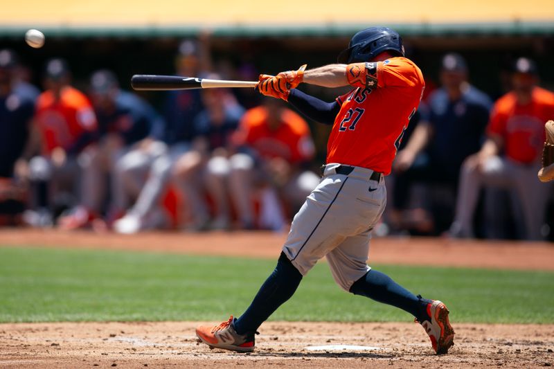 Jul 24, 2024; Oakland, California, USA; Houston Astros second baseman Jose Altuve (27) hits an RBI single against the Oakland Athletics during the second inning at Oakland-Alameda County Coliseum. Mandatory Credit: D. Ross Cameron-USA TODAY Sports