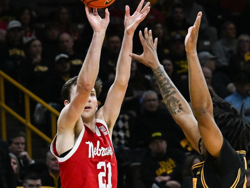 Feb 17, 2026; Iowa City, Iowa, USA; Nebraska Cornhuskers forward Pryce Sandfort (21) shoots the ball as Iowa Hawkeyes guard Tavion Banks (6) defends during the first half at Carver-Hawkeye Arena. Mandatory Credit: Jeffrey Becker-Imagn Images