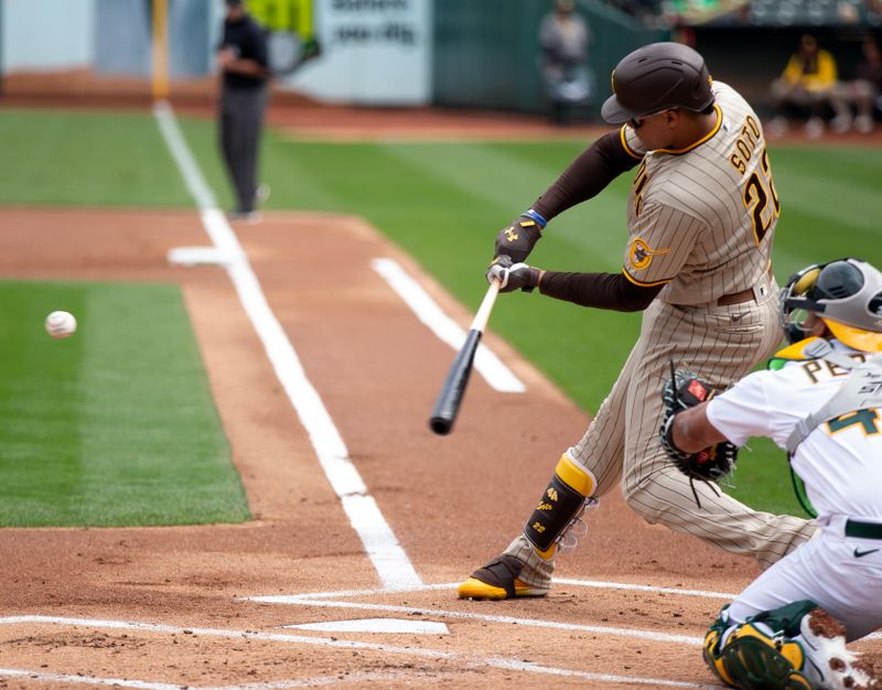 Sep 16, 2023; Oakland, California, USA; San Diego Padres left fielder Juan Soto (22) hits a sacrifice fly against the Oakland Athletics during the first inning at Oakland-Alameda County Coliseum. Mandatory Credit: D. Ross Cameron-USA TODAY Sports