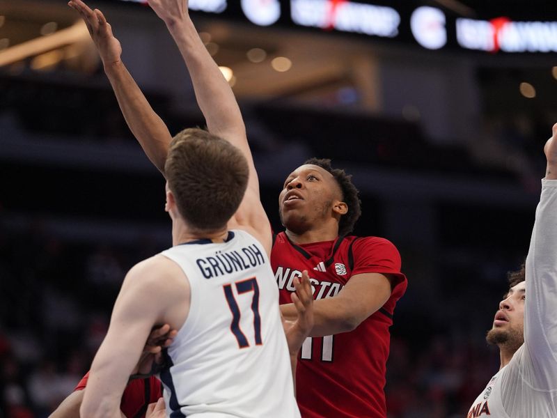 Mar 12, 2026; Charlotte, NC, USA; NC State Wolfpack guard Quadir Copeland (11) goes to the basket against Virginia Cavaliers center Johann Grünloh (17) during the second half at Spectrum Center. Mandatory Credit: Jim Dedmon-Imagn Images