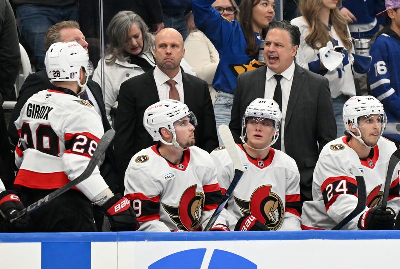 Apr 22, 2025; Toronto, Ontario, CAN;  Ottawa Senators head coach Travis Green speaks to his players during a timeout against the Toronto Maple Leafs in the second period in game two of the first round of the 2025 Stanley Cup Playoffs at Scotiabank Arena. Mandatory Credit: Dan Hamilton-Imagn Images
