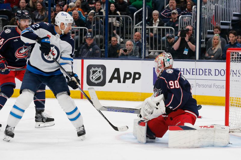 Mar 17, 2024; Columbus, Ohio, USA; Columbus Blue Jackets goalie Elvis Merzlikins (90) makes a save on the shot from Winnipeg Jets right wing Nino Niederreiter (62) during the first period at Nationwide Arena. Mandatory Credit: Russell LaBounty-USA TODAY Sports