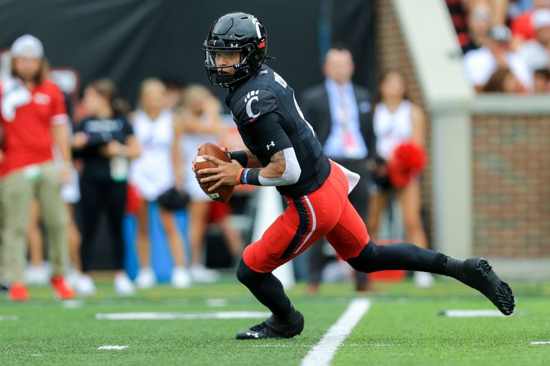 Sep 4, 2021; Cincinnati, Ohio, USA; Cincinnati Bearcats quarterback Desmond Ridder (9) carries the ball against the Miami (Oh) Redhawks in the first half at Nippert Stadium. Mandatory Credit: Aaron Doster-USA TODAY Sports