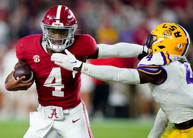 Nov 4, 2023; Tuscaloosa, Alabama, USA; Alabama Crimson Tide quarterback Jalen Milroe (4) scrambles up the field against LSU Tigers linebacker Harold Perkins Jr. (4)  during the second half at Bryant-Denny Stadium. Alabama Crimson Tide defeated the LSU Tigers 42-28. Mandatory Credit: John David Mercer-USA TODAY Sports