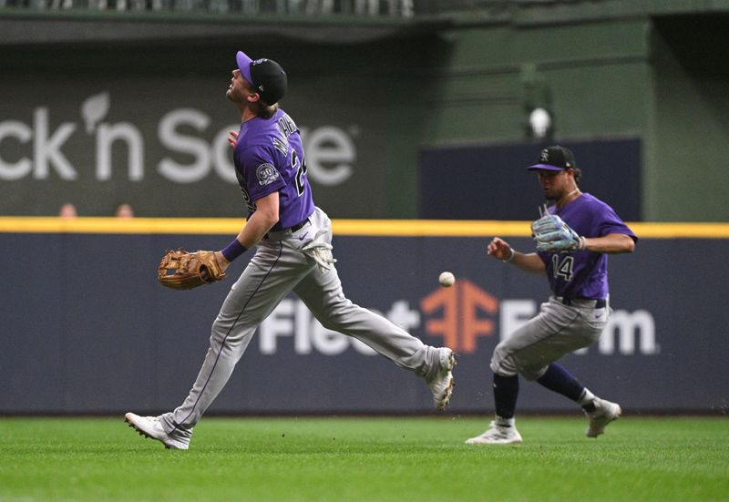 Aug 7, 2023; Milwaukee, Wisconsin, USA; Colorado Rockies third baseman Ryan McMahon (24) looses sight of the ball and it drops in the outfield against the Colorado Rockies in the fourth inning at American Family Field. Mandatory Credit: Michael McLoone-USA TODAY Sports