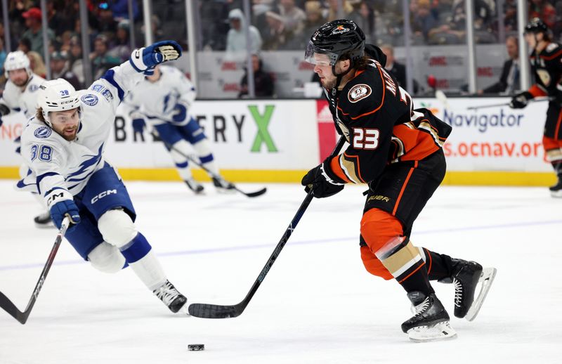 Mar 24, 2024; Anaheim, California, USA; Anaheim Ducks center Mason McTavish (23) passes against Tampa Bay Lightning left wing Brandon Hagel (38) during the first period at Honda Center. Mandatory Credit: Jason Parkhurst-USA TODAY Sports