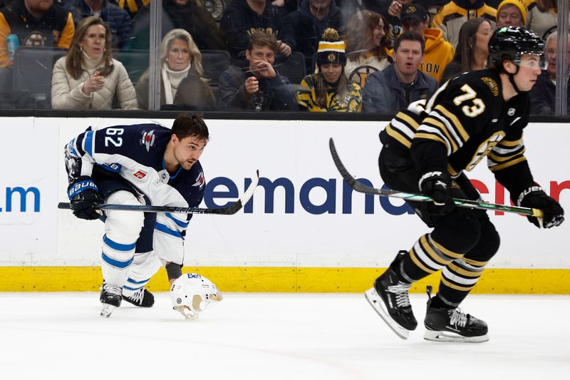 Jan 22, 2024; Boston, Massachusetts, USA; Winnipeg Jets right wing Nino Niederreiter (62) picks up his helmet after it was knocked off on a check by Boston Bruins defenseman Charlie McAvoy (73) during the third period at TD Garden. Mandatory Credit: Winslow Townson-USA TODAY Sports