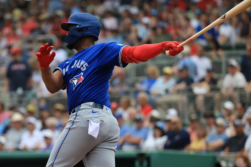 Feb 22, 2026; Fort Myers, Florida, USA; Toronto Blue Jays designated hitter Eloy Jimenez (74) hits an RBI double during the first inning against the Boston Red Sox  at JetBlue Park at Fenway South. Mandatory Credit: Kim Klement Neitzel-Imagn Images