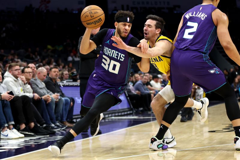 CHARLOTTE, NORTH CAROLINA - FEBRUARY 12: T.J. McConnell #9 of the Indiana Pacers defends Seth Curry #30 of the Charlotte Hornets during the first half of an NBA game at Spectrum Center on February 12, 2024 in Charlotte, North Carolina. NOTE TO USER: User expressly acknowledges and agrees that, by downloading and or using this photograph, User is consenting to the terms and conditions of the Getty Images License Agreement. (Photo by David Jensen/Getty Images)