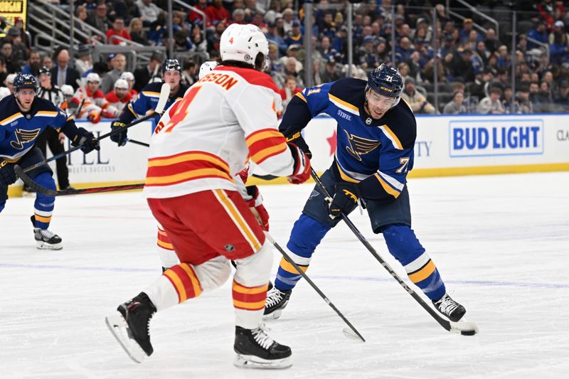 Jan 14, 2025; St. Louis, Missouri, USA; Calgary Flames defenseman Rasmus Andersson (4) defends against St. Louis Blues right wing Mathieu Joseph (71) as he takes a shot in the second period at Enterprise Center. Mandatory Credit: Joe Puetz-Imagn Images