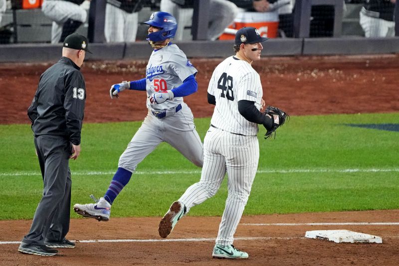 Oct 30, 2024; New York, New York, USA; Los Angeles Dodgers shortstop Mookie Betts (50) reaches first base after New York Yankees first baseman Anthony Rizzo (48) and the New York Yankees could not make a play on the ball in game four of the 2024 MLB World Series at Yankee Stadium. Mandatory Credit: Robert Deutsch-Imagn Images
