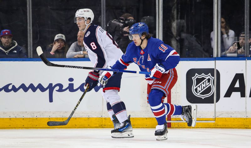 Jan 18, 2025; New York, New York, USA; Columbus Blue Jackets defenseman Zach Werenski (8) and New York Rangers left wing Artemi Panarin (10) look for the puck during the first period at Madison Square Garden. Mandatory Credit: Danny Wild-Imagn Images