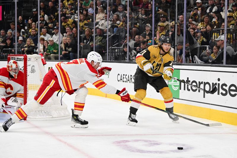 Oct 28, 2024; Las Vegas, Nevada, USA; Vegas Golden Knights center William Karlsson (71) passes the puck past Calgary Flames defenseman Kevin Bahl (7) in the second period at T-Mobile Arena. Mandatory Credit: Candice Ward-Imagn Images