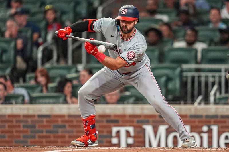 May 29, 2024; Cumberland, Georgia, USA; Washington Nationals first baseman Joey Gallo (24) bunts for a single against the Atlanta Braves during the eighth inning at Truist Park. Mandatory Credit: Dale Zanine-USA TODAY Sports